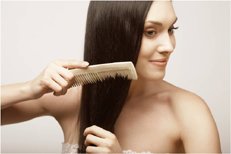 pic of a woman brushing her hair, showing how a skinny body type needs protein for hair, skin, nails etc.